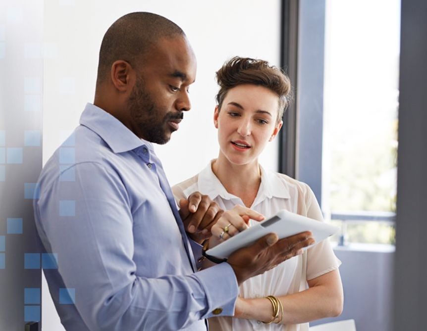 Colleagues discussion healthcare while looking at a tablet